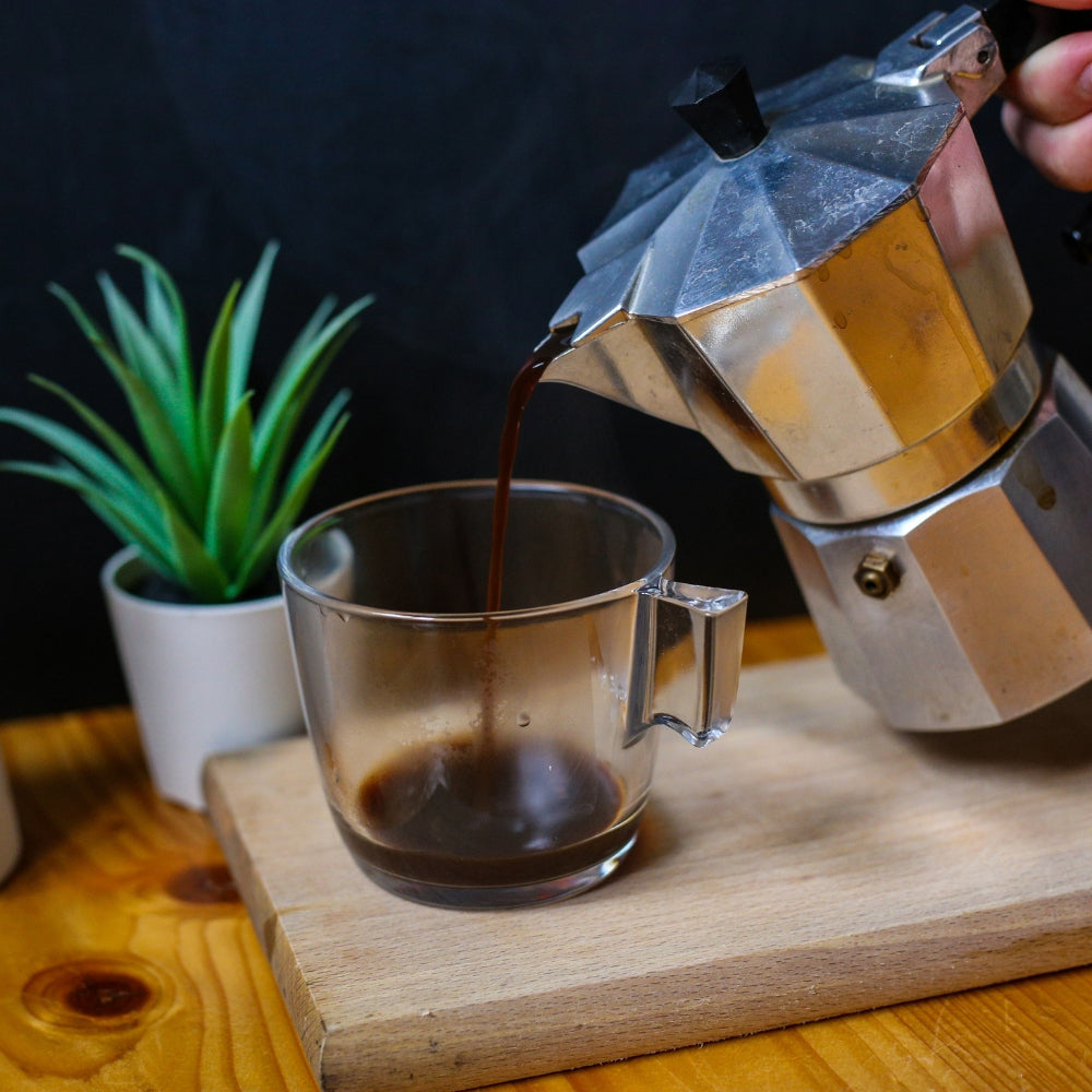 pouring coffee into a cup from a moka pot
